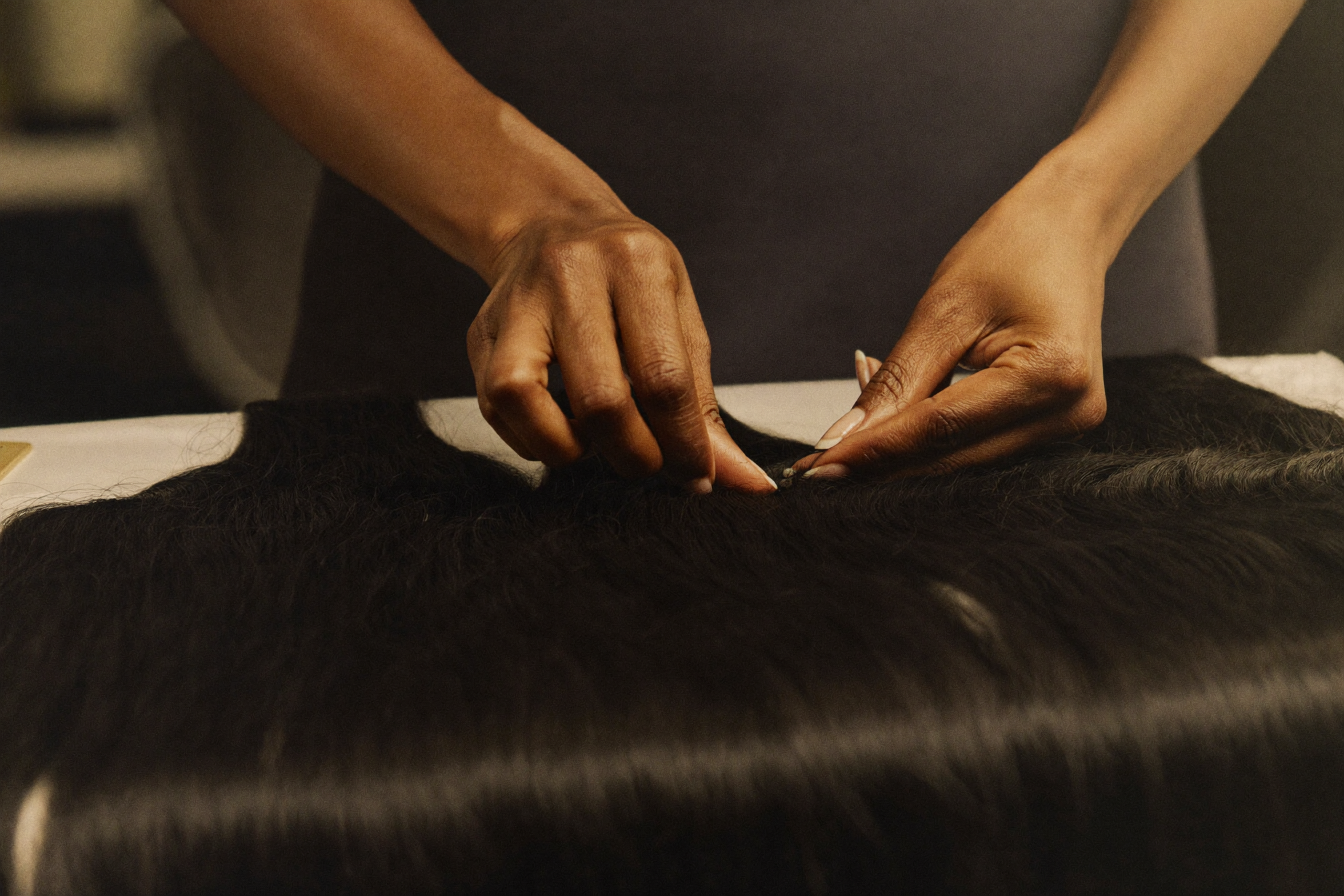 An independent hair professional installing premium hair in a studio